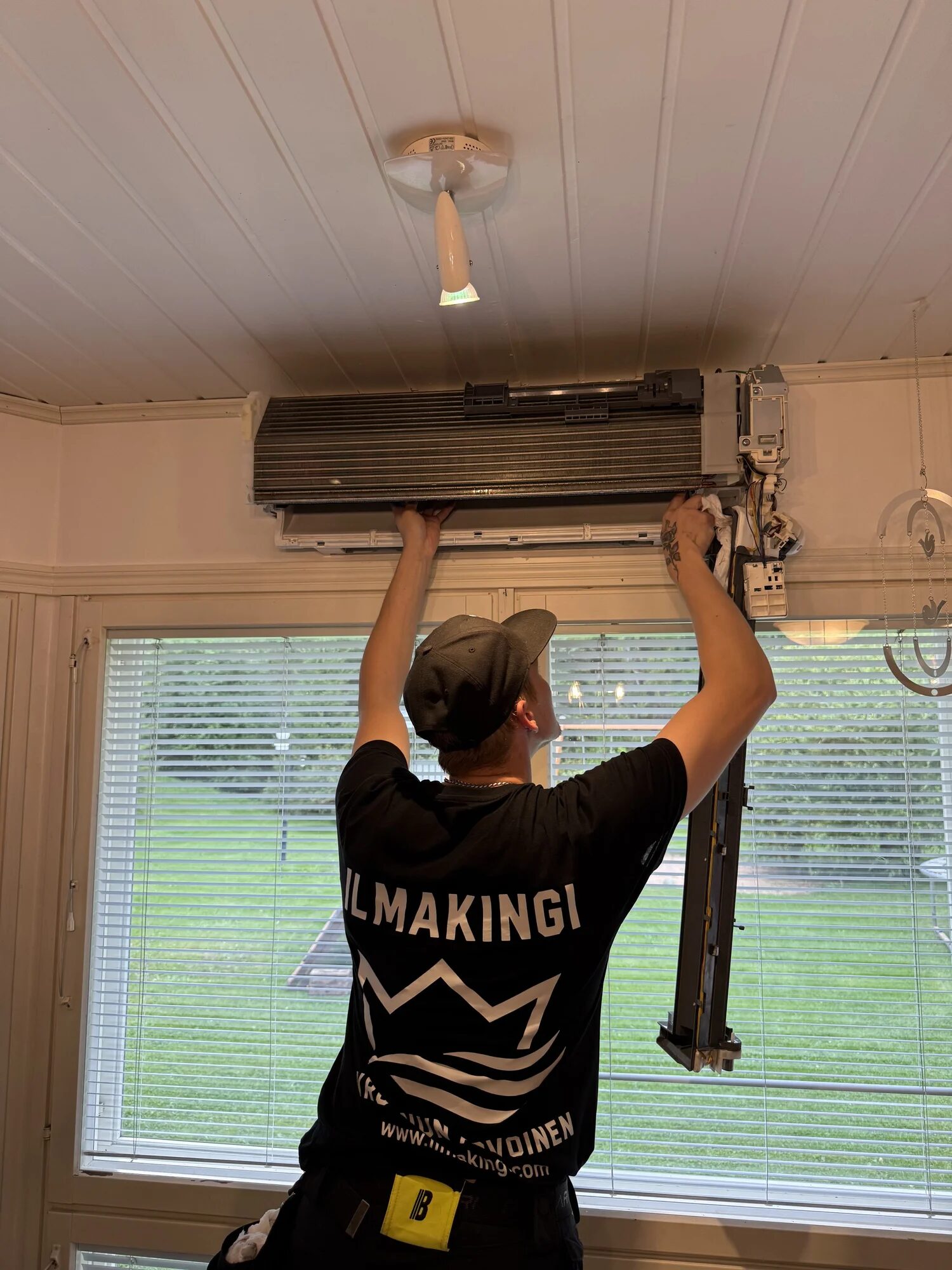 IlmaKingin asentaja huoltaa ilmalämpöpumpun sisäyksikköä